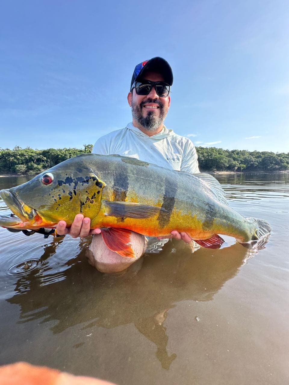 Hóspede com tucunaré em registro de pesca esportiva